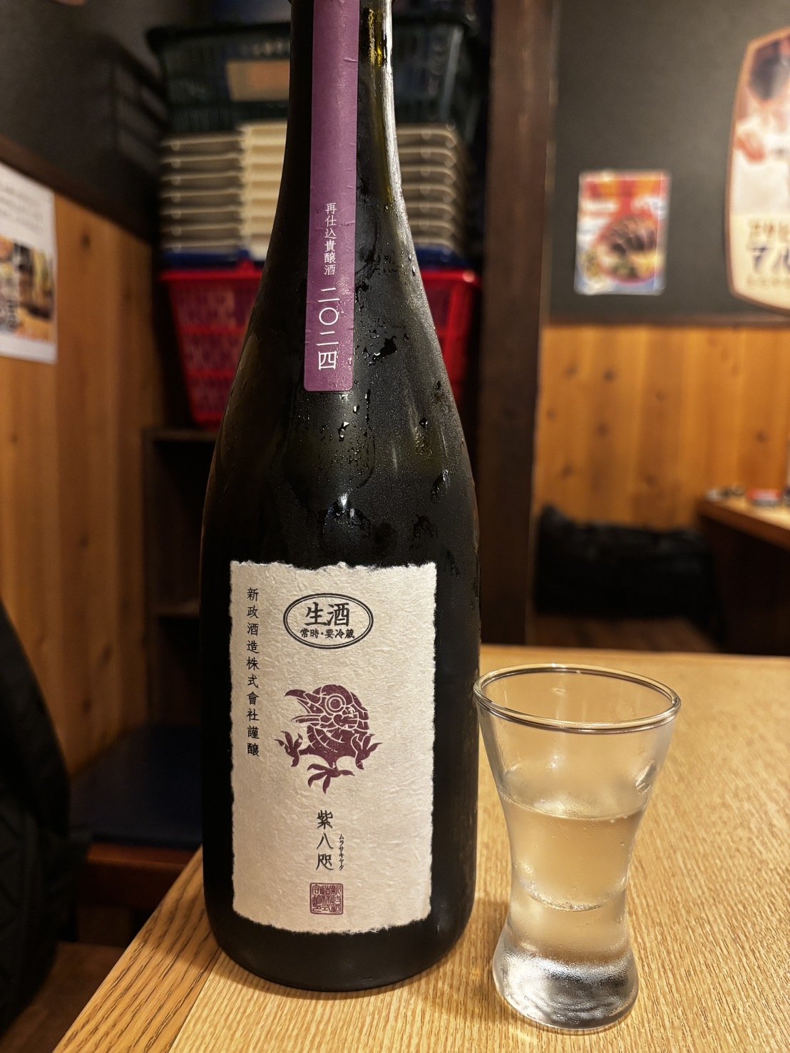 卓に置かれた日本酒の瓶と、猪口に注がれた酒